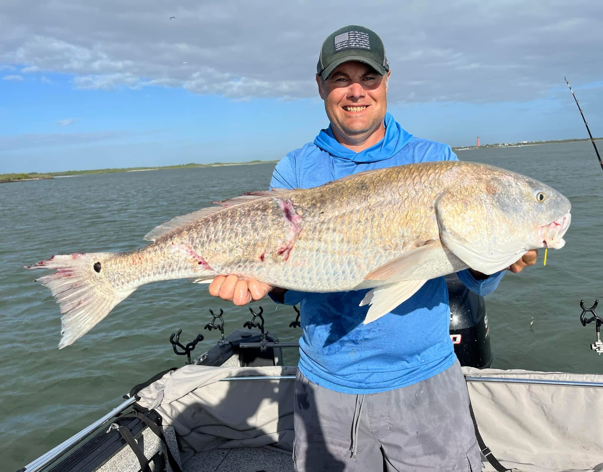 Angler holding a large redfish aboard Captain Q Charters