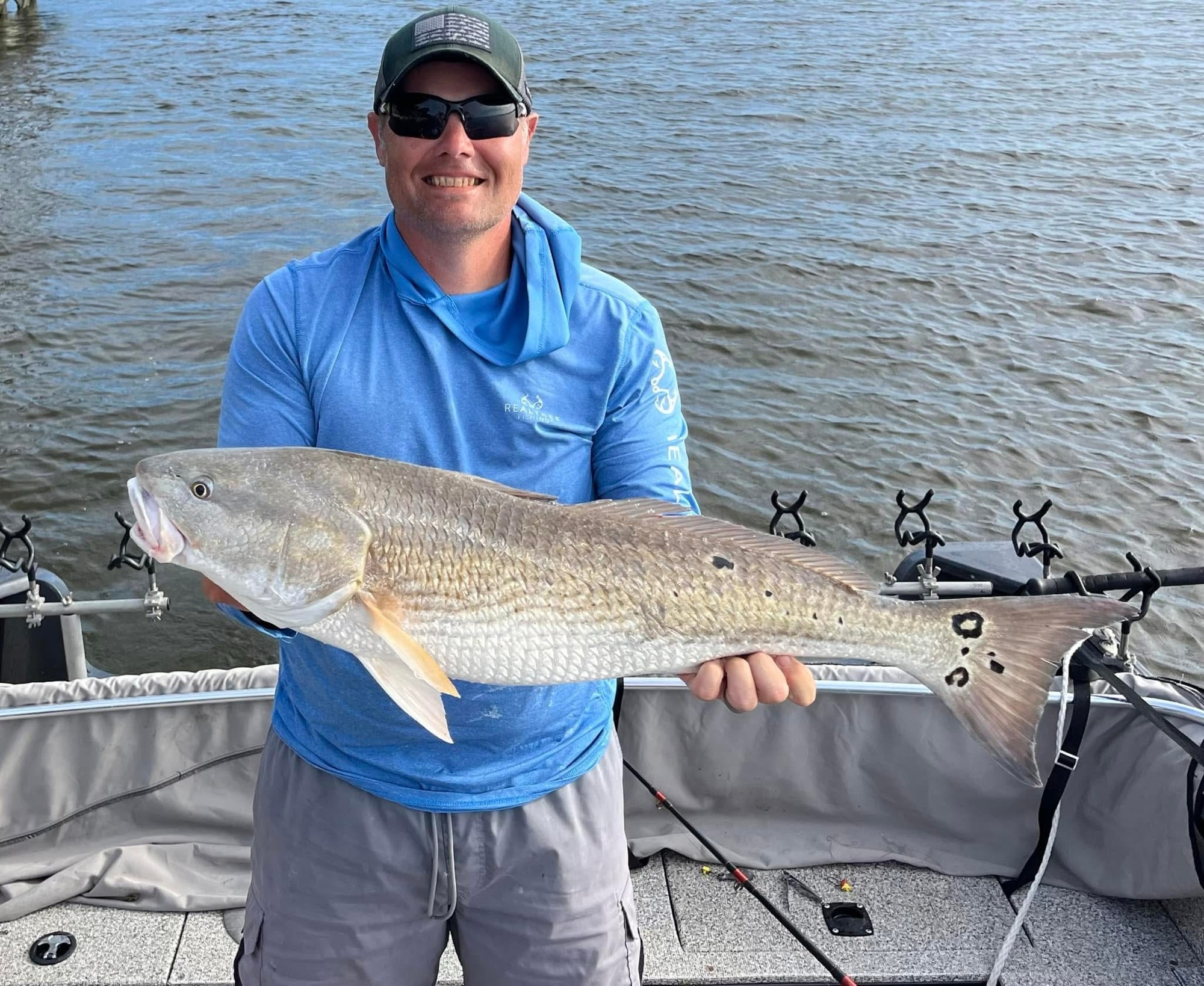 Angler holding a redfish horizontally aboard the boat